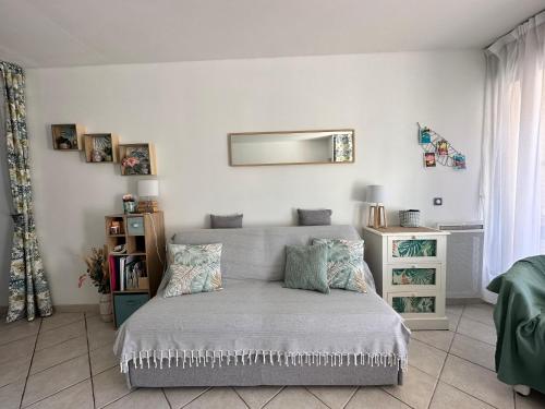 une chambre avec un lit et un miroir au mur dans l'établissement HYEBOUG Appartement pour 4 personnes dans résidence avec piscine situé sur le port d'Hyères, à Hyères