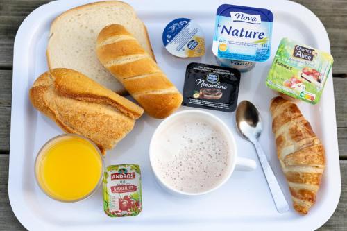 a plate of breakfast food with bread and a cup of coffee at Premiere Classe Angers Beaucouzé in Beaucouzé