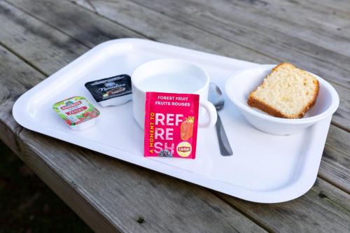 a plate with a cup of coffee and a piece of bread at Premiere Classe Angers Beaucouzé in Beaucouzé