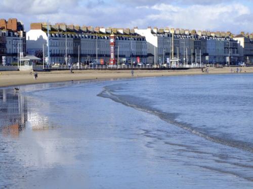 a view of a beach with buildings in the background at 1 bed self catering apartment in Weymouth