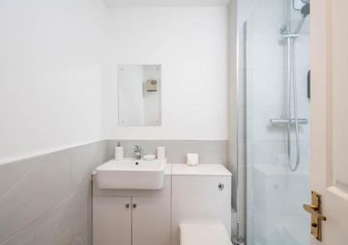 a white bathroom with a sink and a shower at Pet Friendly - 1 Bedroom Apartment with Parking in Crawley By Sublime Stays in Crawley
