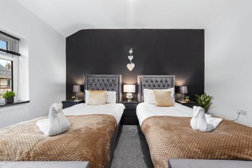 um quarto com 2 camas e almofadas brancas em Luxury by the Sea Blackpool's Finest Getaway for 8 em Blackpool
