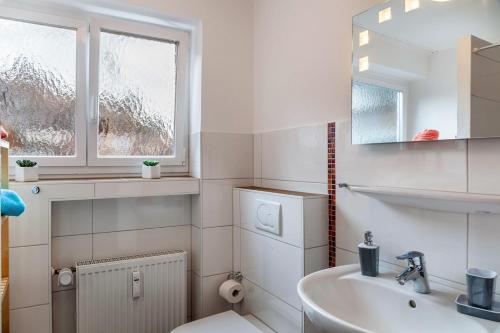 uma casa de banho com um lavatório, um WC e um espelho. em Ferienwohnung Alpenglück em Mittenwald
