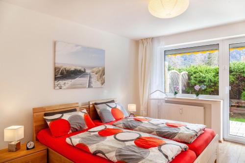 ミッテンヴァルトにあるFerienwohnung Alpenglückのベッドルーム1室(赤いベッド1台、窓付)