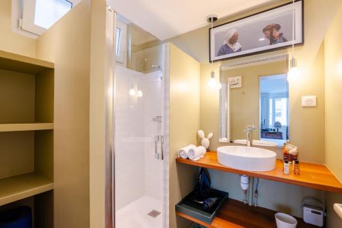 une salle de bain avec un lavabo et une douche dans l'établissement Veeve - Culture and Colour, à Paris