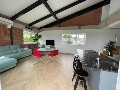 a kitchen and living room with a couch and a table at Casa Albuerne in Gijón