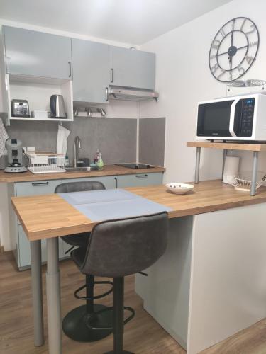 une cuisine avec un bureau, un four micro-ondes et une chaise dans l'établissement Superbe T2 proche cathédrale et Loire, à Tours