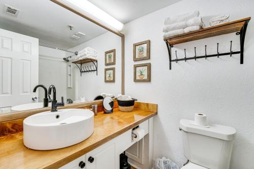 een badkamer met een wastafel, een toilet en een spiegel bij Resort-Style Orlando Studio Steps to Beach! in Orlando