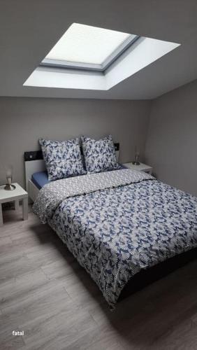 une chambre avec un lit et une lucarne dans l'établissement maison pas loin centre-ville, à Reims