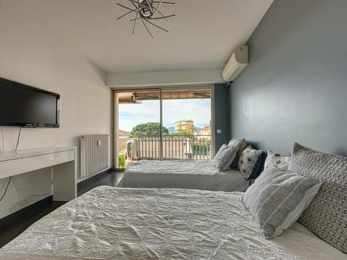 une chambre avec deux lits et une télévision à écran plat dans l'établissement AGENCIA appartement 2 chambres au Suquet, à Cannes