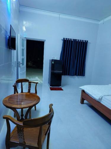富國的住宿－Nhà Nghỉ Tốt Hơn，配有桌椅和床的房间