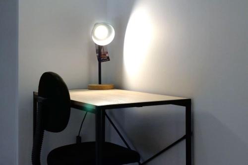 un escritorio con una silla y una luz en él en L’Impérial - HyperCentre - WIFI, en Étampes