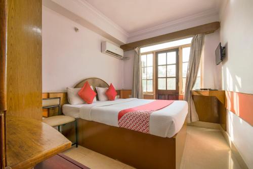 a hotel room with a bed and a window at Collection O 10885 Hotel Keerthana International in Kammasandra