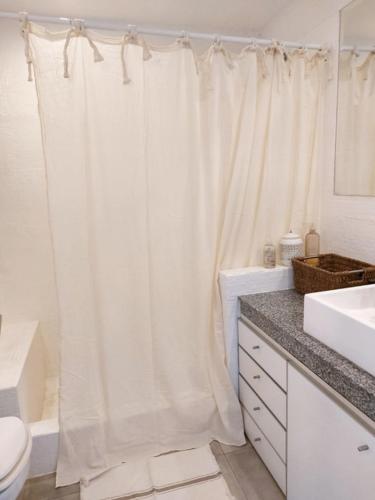 a bathroom with a white shower curtain and a toilet at Single Room in Ibiza Town