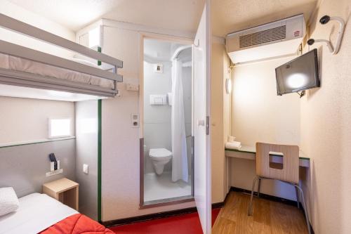 a small room with a bed and a bathroom at Premiere Classe Angers Beaucouzé in Beaucouzé