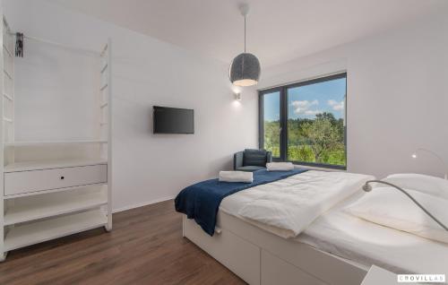 a white bedroom with a bed and a window at Complex Teca in Petehi