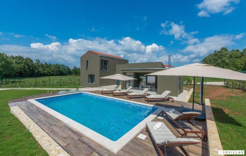 a pool with chairs and umbrellas next to a house at Complex Teca in Petehi