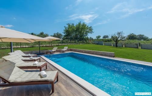 a swimming pool with chairs and umbrellas next to at Complex Teca in Petehi
