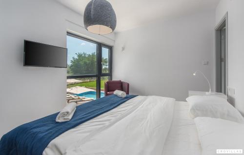 a white bedroom with a bed and a tv at Complex Teca in Petehi