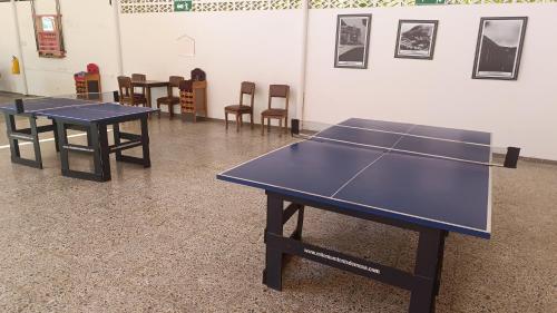 2 mesas de ping pong en una habitación con sillas en Bavaria Real Hotel & Club, en Honda