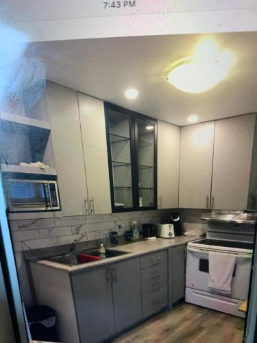 a kitchen with white cabinets and a sink and a stove at Ottawa Heritage Private Rooms Across OttawaU Not Entire Apt in Ottawa