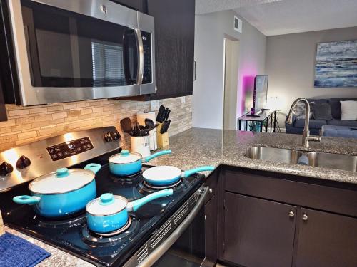 a kitchen with a stove with four pots and pans at Escape To Island Bay - Walk To Moody Gardens in Houston