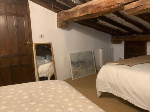 a bedroom with two beds and a mirror at Patones de Arriba Brother Law SL in Patones
