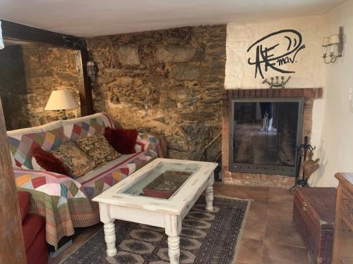 ein Wohnzimmer mit einem Sofa und einem Kamin in der Unterkunft Patones de Arriba in Patones