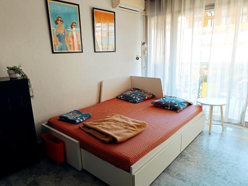 Zimmer mit einem Bett mit zwei Kissen darauf in der Unterkunft logement climatisé à Juan les Pins dans résidence avec piscine in Juan-les-Pins