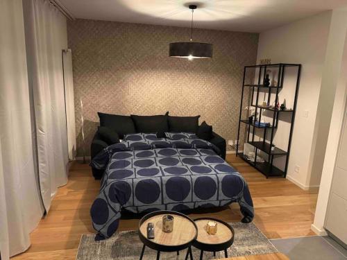 a bedroom with a large bed and two tables at Charmant Studio in Geneva