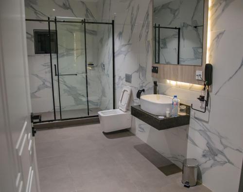 bagno con doccia, lavandino e servizi igienici di The Safron Hotel a Lagos