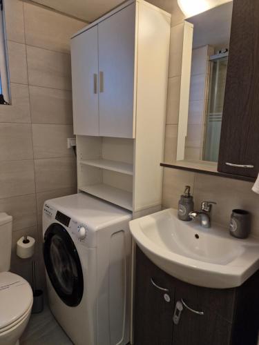 uma casa de banho com uma máquina de lavar roupa e um lavatório em Dantis Place in Nafplio vol.2 em Nafplio