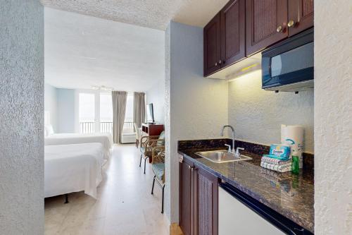 a hotel room with a bed and a kitchen with a sink at Bayside at Sandestin #6580 in Destin