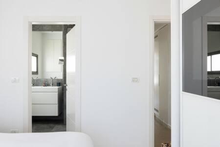 a white room with a kitchen and a mirror at Peaceful Terrace by Five Stay in Tel Aviv