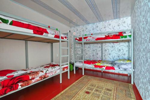 a bedroom with two bunk beds and a red floor at Apple Hostel Cholpon Ata in Cholpon-Ata