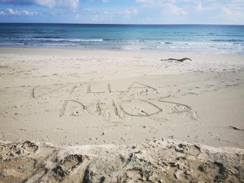 una palabra escrita en la arena en una playa en Villa Mios, en Muro Leccese