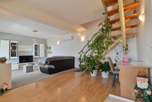 een woonkamer met een bank en een trap bij Rina Vacation home in Trogir