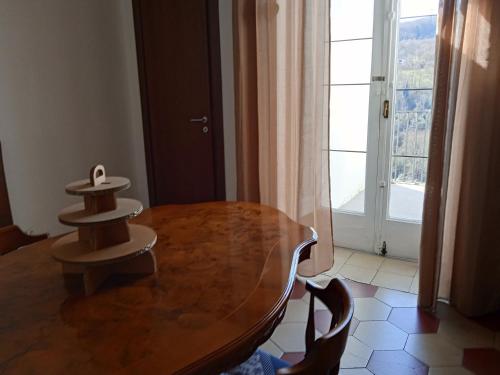 a wooden table in a room with a large window at Casa di Paola a Tufo in Santa Paolina