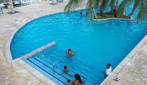 eine Gruppe von Personen in einem Pool mit blauem Wasser in der Unterkunft Maison Baie Retreat in Discovery Bay