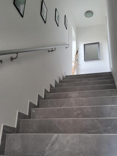 a set of stairs in a white room with a mirror at Apartmán Gabriela in Roudné