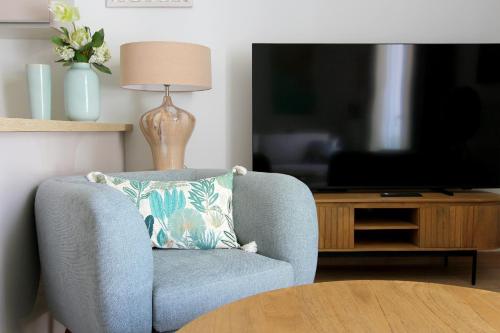- une chaise bleue avec un oreiller dans le salon dans l'établissement Cristal3 ~ Superbe appartement proche Disneyland, à Serris