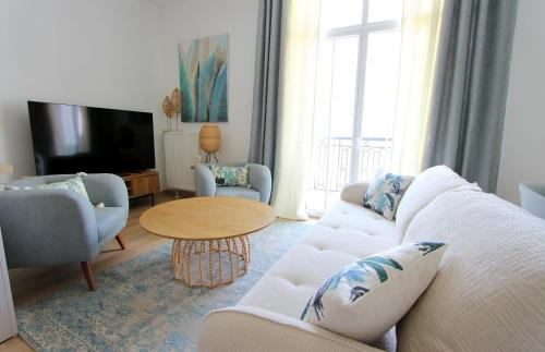 un salon avec un canapé, des chaises et une télévision dans l'établissement Cristal3 ~ Superbe appartement proche Disneyland, à Serris