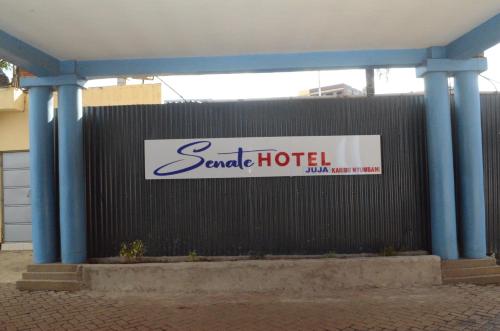a sign for a santa hotel on a fence at HOTEL SENATE JUJA in Thika