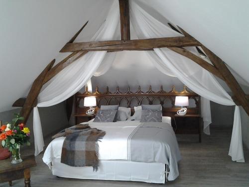 a bedroom with a white bed with a canopy at Manoir des Roches 41 in Bourré