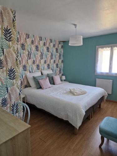 a bedroom with a large bed with pink pillows at Maisons cosy de village in Gurgy