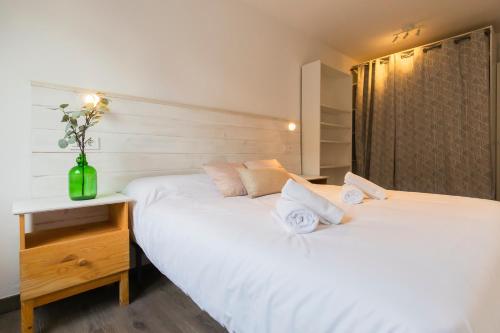 two white beds in a room with a desk at AkomodaT en apartamento luminoso junto al paseo de la ría in Bilbao