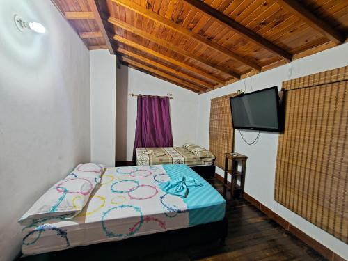 een slaapkamer met een bed en een flatscreen-tv bij Finca Recreativa Aguamarino Doradal in Doradal