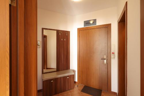 a bathroom with a wooden door and a mirror at Pirin Golf Mountain View Retreat in Razlog