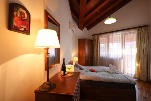 ein Schlafzimmer mit einem Bett mit einer Lampe und einem Fenster in der Unterkunft Pirin Golf Mountain View Retreat in Raslog