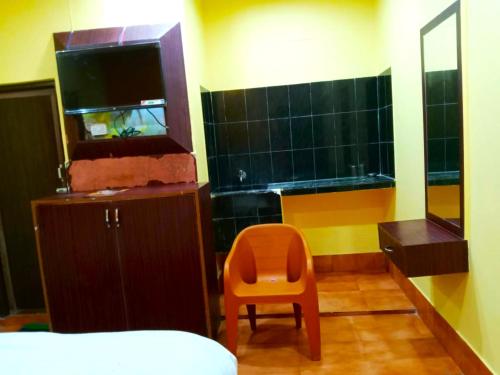 a bathroom with a orange chair and a fish tank at Goroomgo Sahoo Palace Puri Near Sea Beach in Puri